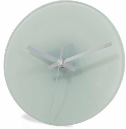 Round wall clock with a light green face and white hands on a white background